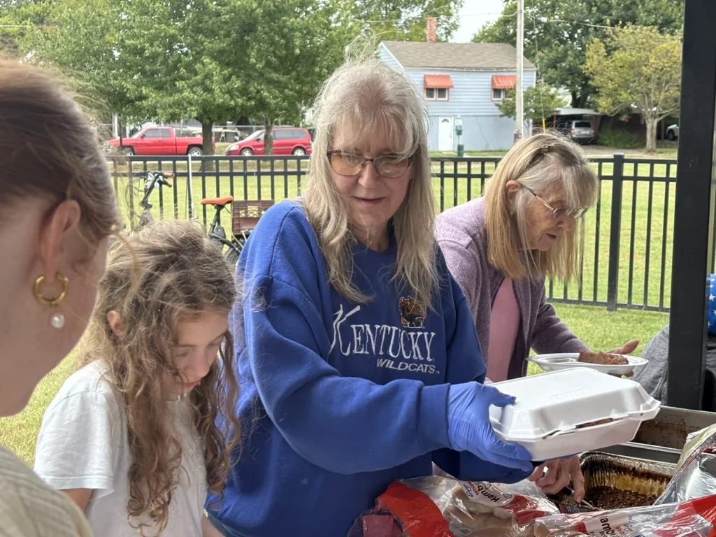 Volunteers filling meal containers during homeless outreach