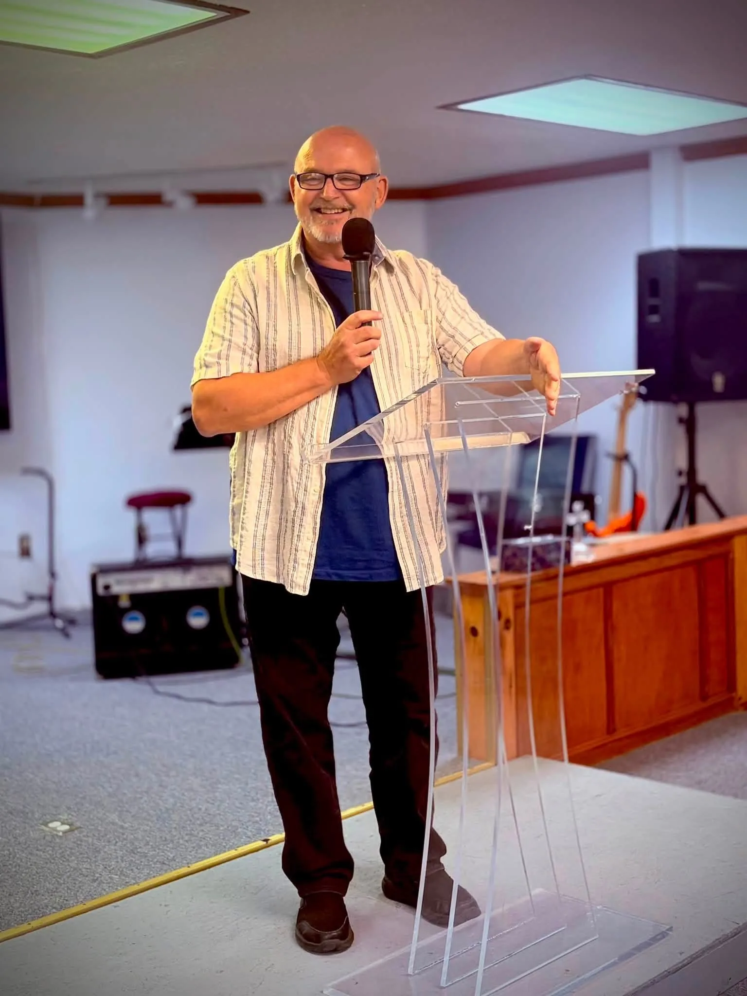 Pastor Tom preaching behind a clear lectern
